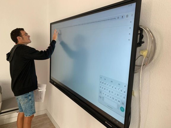 Usuario escribiendo en una gran pantalla electrónica